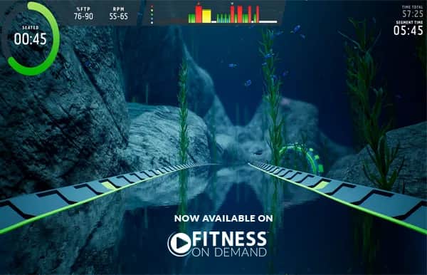 A virtual underwater cycling track winds between rocks and seaweed, with fitness stats and a timer displayed. Text at the bottom reads, Now available on Fitness On Demand.