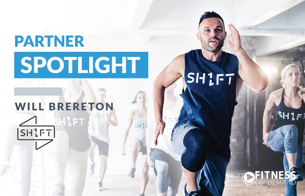 A group fitness class is led by a man in a SHIFT tank top, energetically exercising indoors. Bold text reads Partner Spotlight with Will Brereton and Fitness On Demand logos visible.