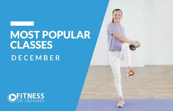 A woman in workout clothes exercises with a dumbbell indoors. Text on a blue background reads: Most Popular Classes December. Fitness On Demand.