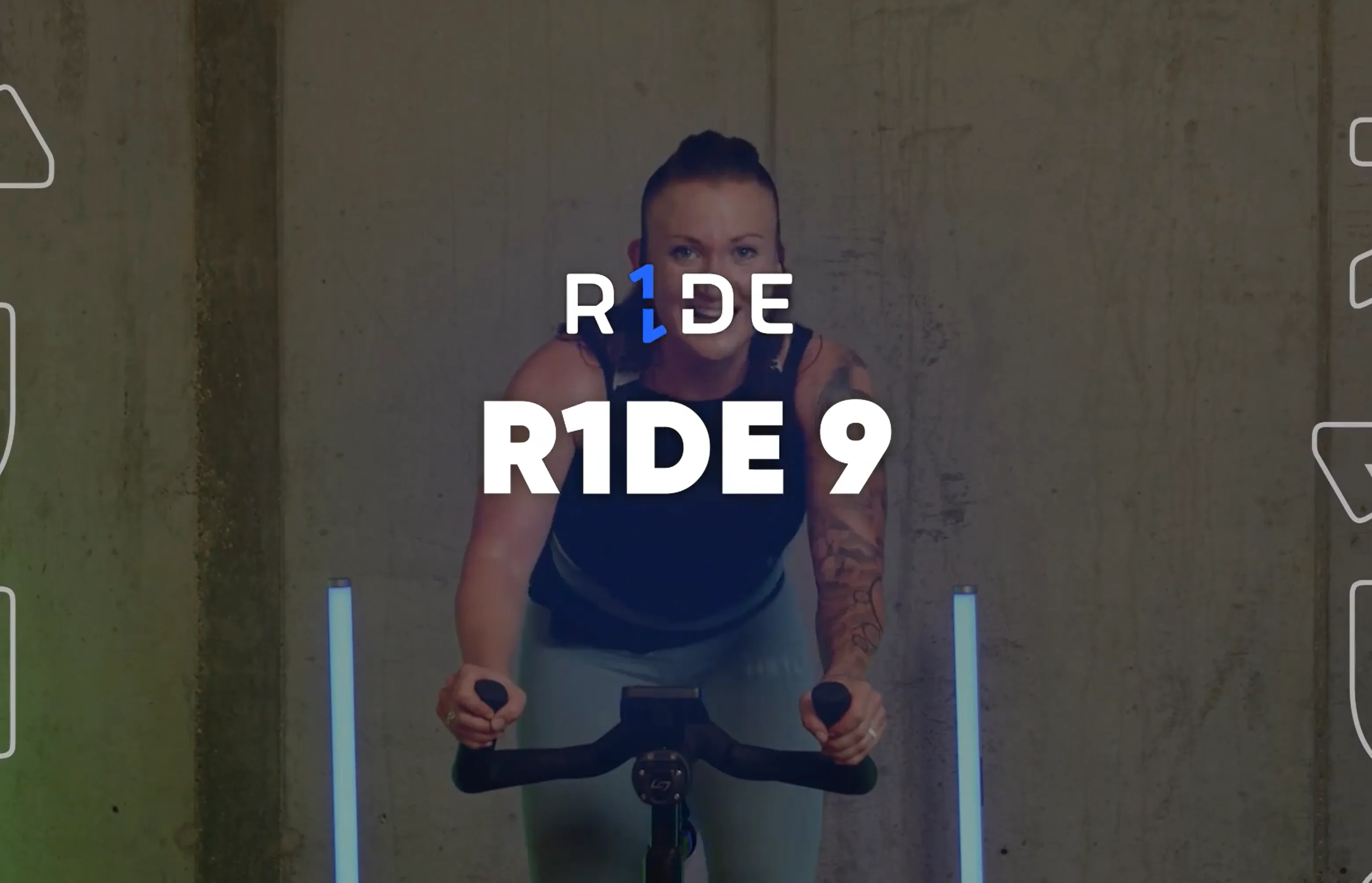 A person rides an exercise bike indoors, leaning forward with hands on the handlebars. The text R1DE R1DE 9 appears over the image. Blue vertical lights are on either side.