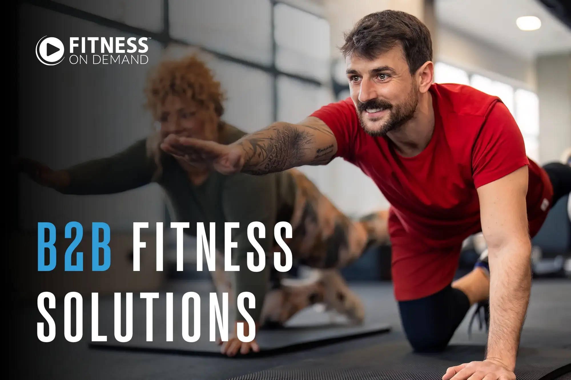 A man in a red shirt and a woman exercise on yoga mats in a gym, stretching with one arm and the opposite leg extended. Text reads: B2B Fitness Solutions. Fitness On Demand logo appear in the upper left corner.