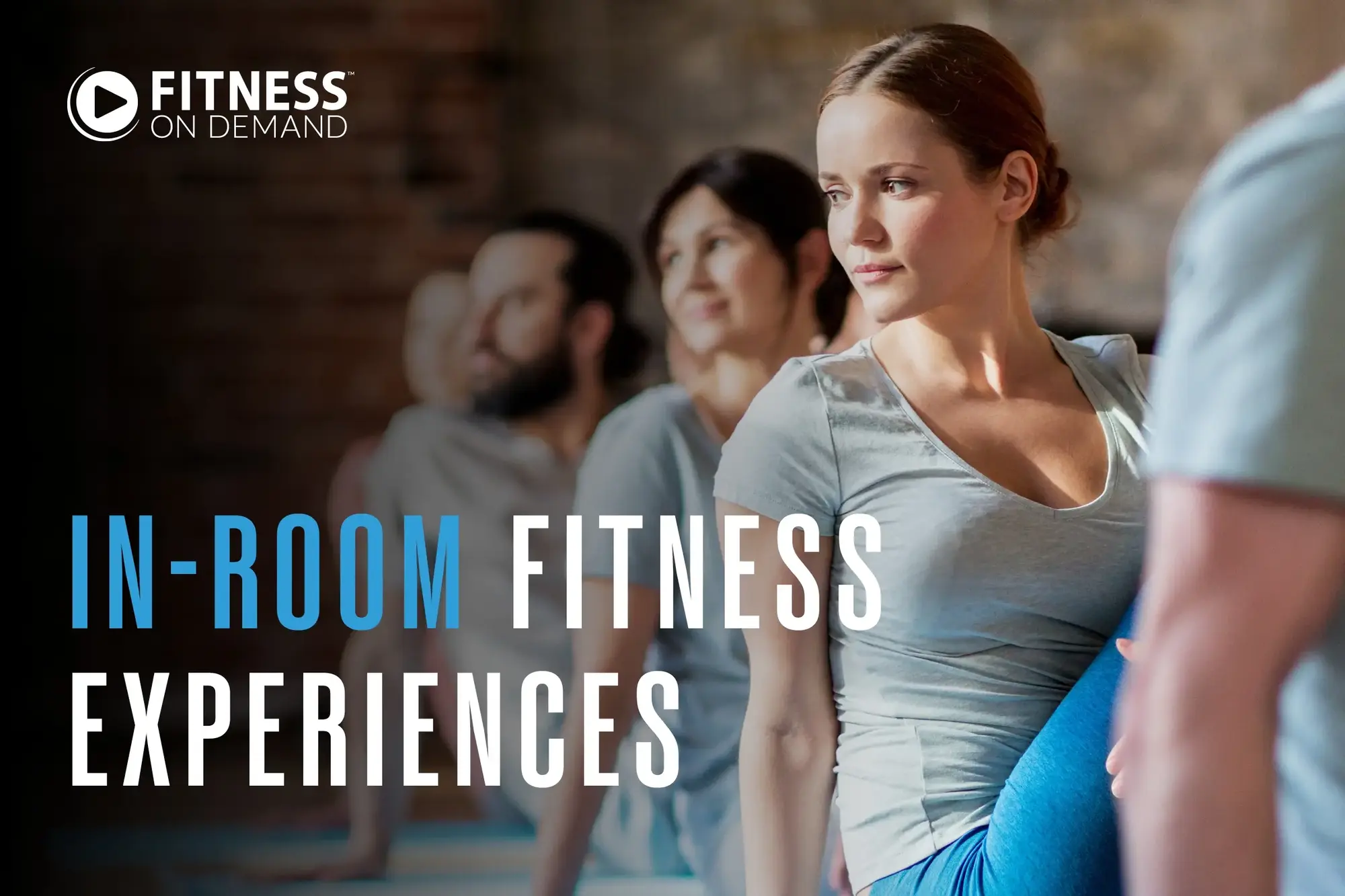A group of people participates in a yoga class, with a woman in the foreground twisting her torso. Text reads: In-Room Fitness Experiences.