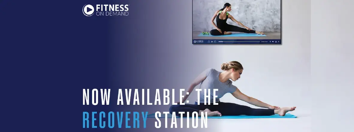 A woman stretches on a blue yoga mat while following an exercise video. The text reads Fitness On Demand. Now Available: The Recovery Station.