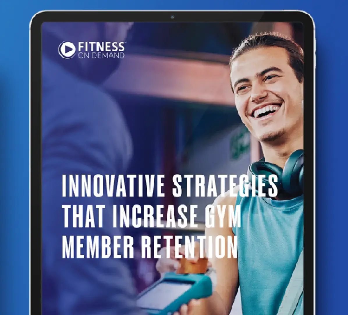 A smiling man in athletic wear with headphones around his neck stands next to gym equipment. Text on the tablet screen reads, Innovative Strategies That Increase Gym Member Retention.