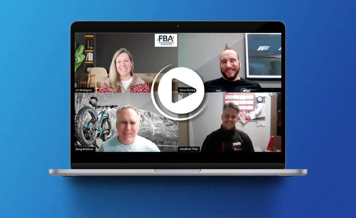 A laptop displays a video call with four smiling participants in separate boxes. The FBA logo appears at the top center. A play button icon overlays the screen, indicating the video can be played. The background is blue.